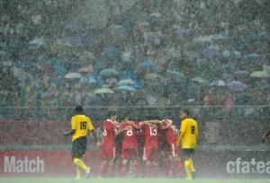 rain pours down as china celebrates a goal