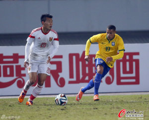 Learning Through Experience: Portugal based midfielder Li Yuanyi picks out a pass as Arsenal loanee Wellington Silva looks on 