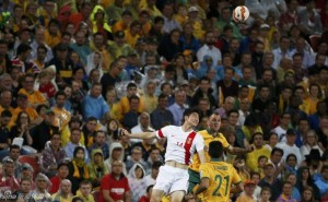 China's Ji Xiang jumps for the ball against Australia's Ivan Franjic and Massimo Luongo during their Asian Cup quarter-final soccer match at the Brisbane Stadium in Brisbane