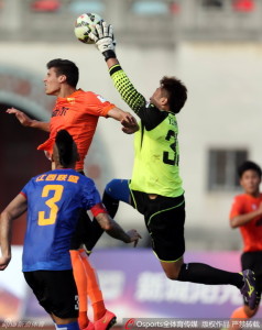 Wuhan's Rafa Jorda challenges Jiangxi goalkeeper Tang Jun for the ball