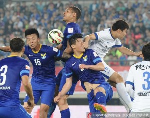 Ouch: Dalian centre back Wang Wanpeng take a blow to the face against Harbin