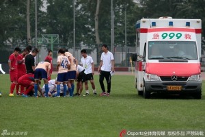 Concerned players look on as medics prepare to take Du Longquan away in an ambulance