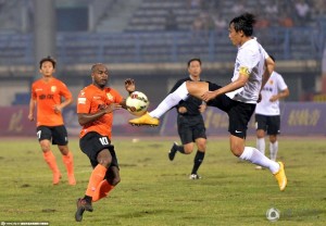 Hebei captain Du Wei clears the ball as Wuhan's Brice Jovial looks on