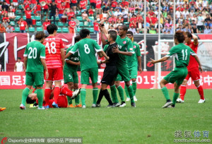 Vicente tries to take the red card shown to Zhu Heng out of the referee's hand