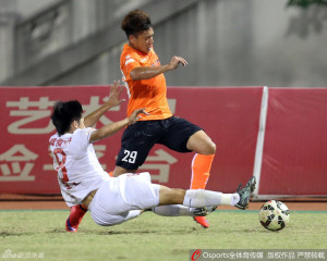 Wang Jun, seen here tackling Wuhan's Yue Xin, converted his fifth penalty of the season late in the game