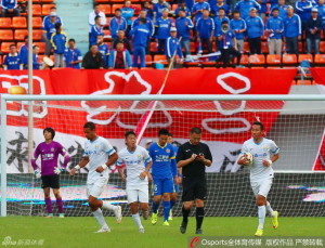 Sun Guowen carries the ball after his equaliser as unhappy Harbin fans look on