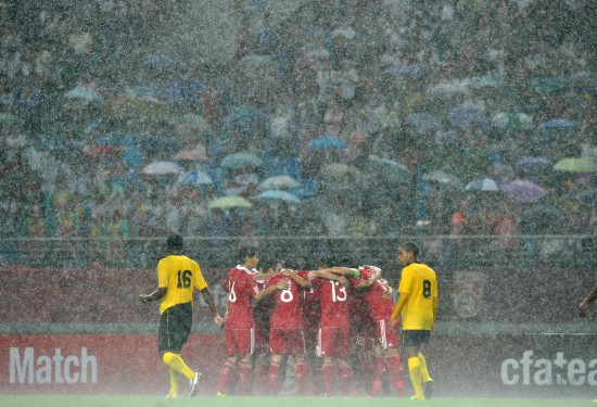 rain pours down as china celebrates a goal